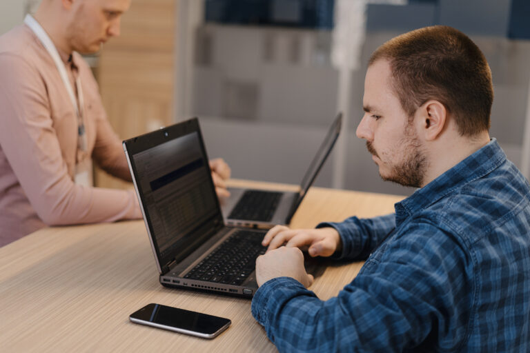 it-codierer-arbeiten-am-laptop-im-buro-am-tisch-scaled